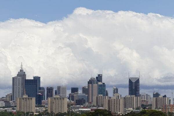 Melbourne skyline against an expansive sky, showcasing a dramatic contrast of dense cumulus clouds and clear areas, visually representing the unpredictable weather patterns often experienced in the city, related to the blog post topic 'why is Melbourne weather unpredictable'.