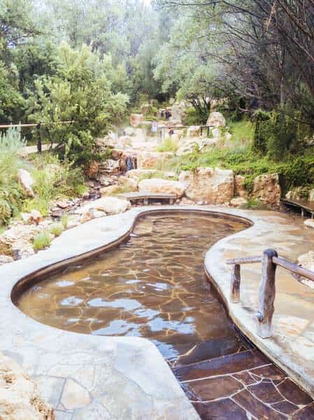 Serene hot springs with winding stone pools surrounded by natural bushland, a relaxing retreat and a popular thing to do near Melbourne during the cooler winter months.