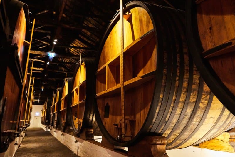 Interior view of a historic whisky distillery near Hobart, featuring large wooden ageing barrels, a highlight for visitors on bespoke Hobart half-day tours that cater to connoisseurs and enthusiasts of fine spirits.