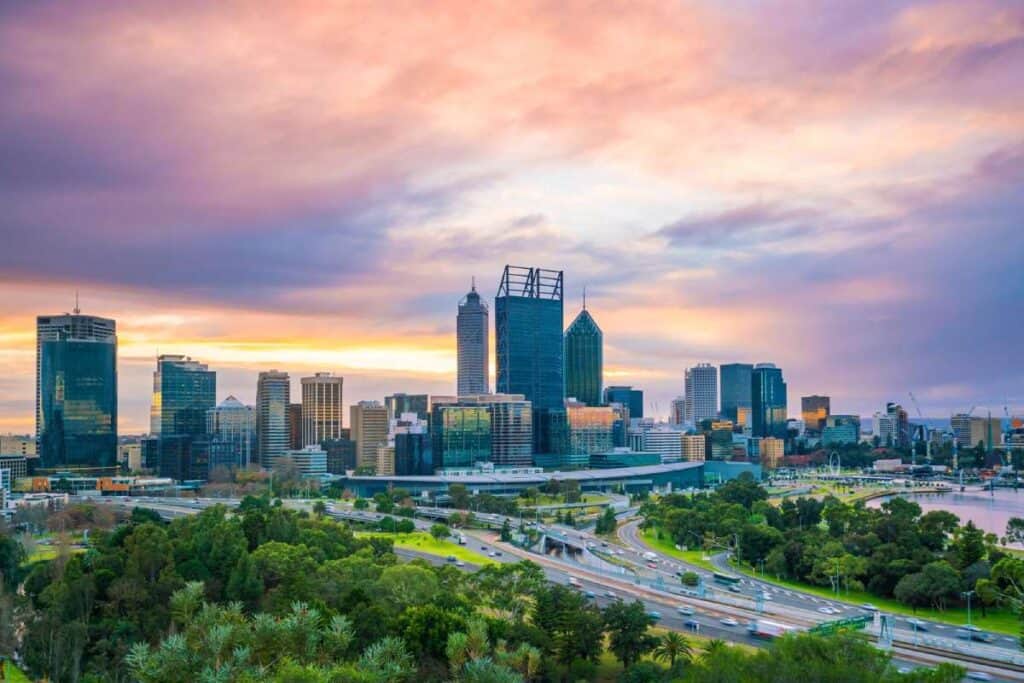 Sunset view of Perth's skyline from Kings Park, with vibrant colours in the sky reflecting on the city’s modern architecture. This image captures one of the best sunset locations in Australia, tying into the blog post about must-see sunset spots.