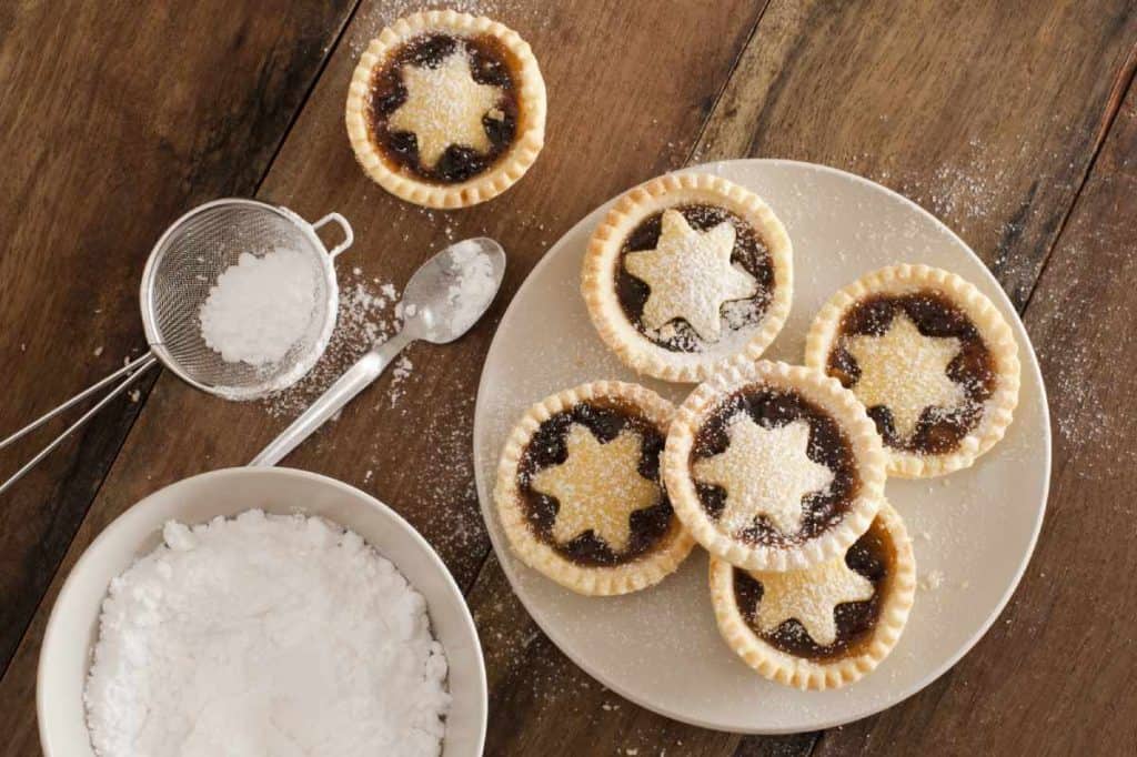 Traditional fruit mince pies dusted with icing sugar, a festive favourite during Australia's Christmas desserts celebrations.
