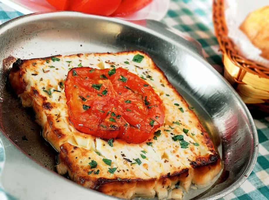 Traditional Greek saganaki cheese topped with a grilled tomato slice, served hot at Atmos, a popular restaurant in Port Stephens. This dish, with its golden, crispy edges and fresh garnish, reflects Atmos's dedication to authentic Mediterranean flavours, making it a standout among the best restaurants in Port Stephens.