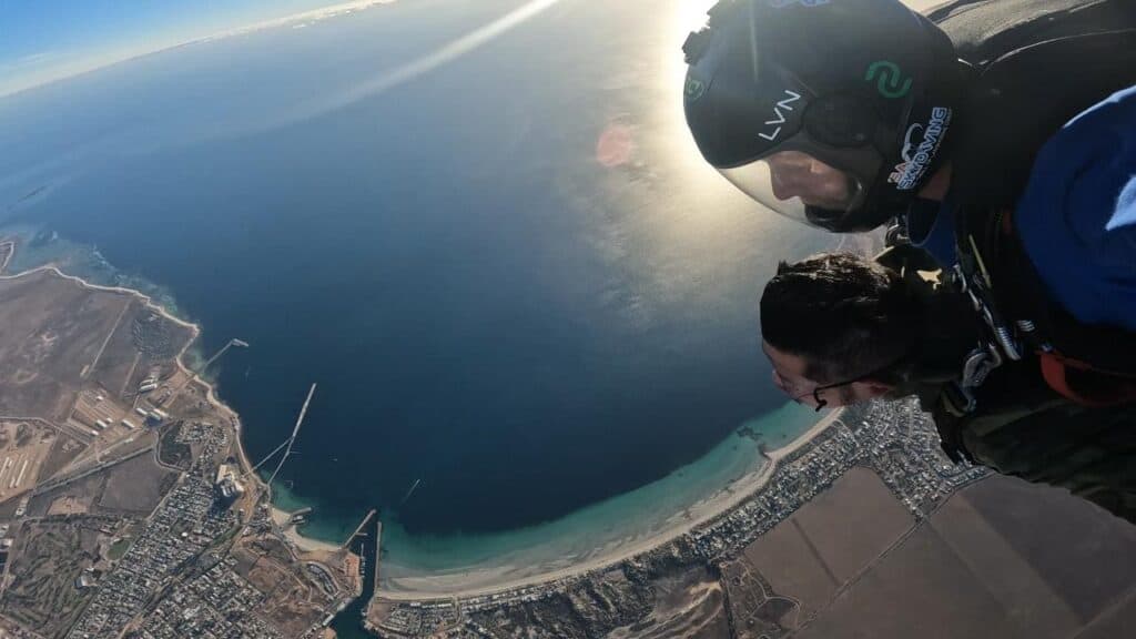 A tandem skydiver and instructor freefall over a coastal area in South Australia, offering a breathtaking aerial view of the shoreline and ocean. This image captures the thrill and stunning scenery of skydiving in South Australia, highlighting the adventure and unique perspectives available.